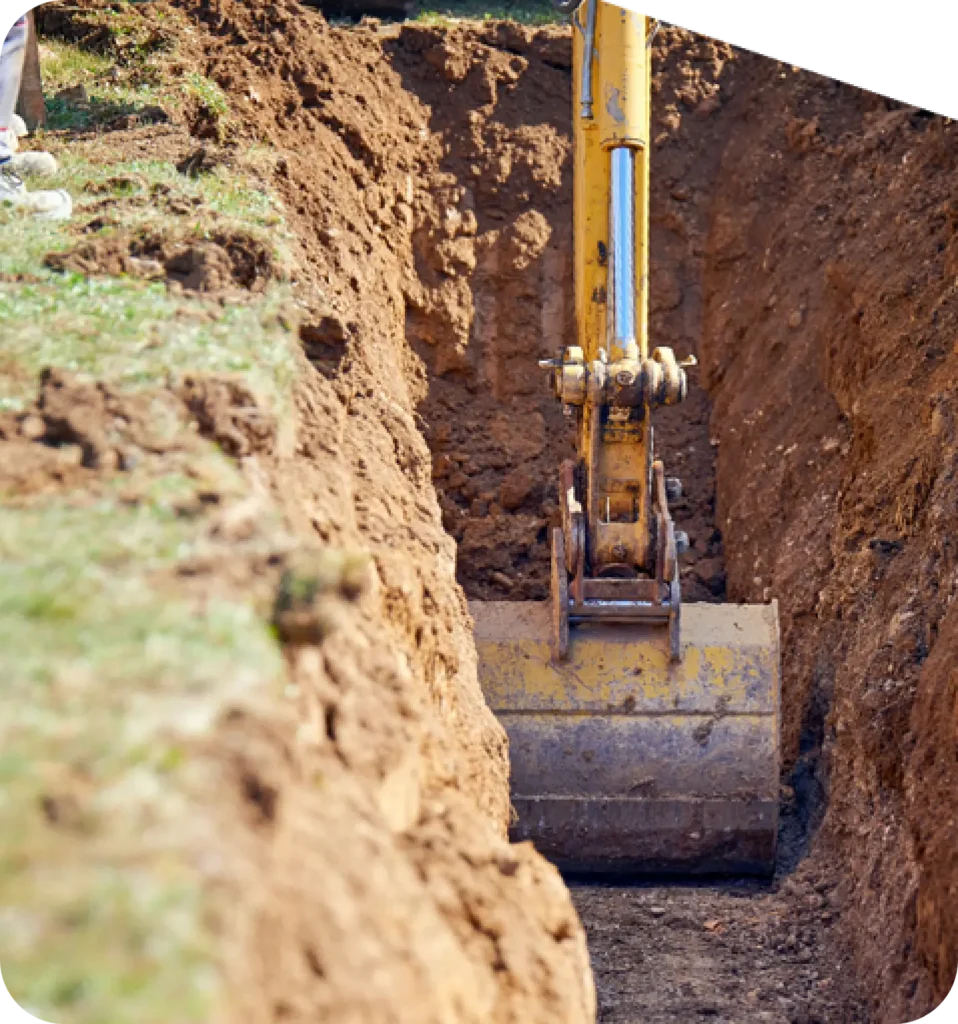 A close-up of a trenching excavator digging a straight trench through compacted earth, showcasing Earthworks Hawkes Bay's trenching expertise.