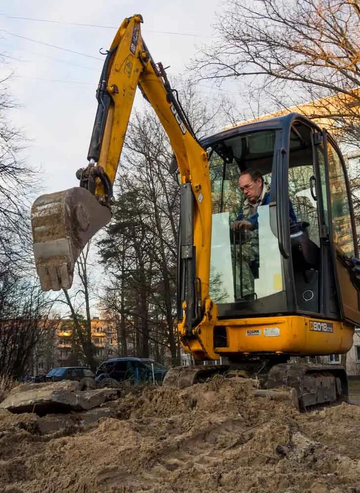 A construction worker operating a mini excavator for small excavations work on a building site with Earthworks Hawkes Bay.