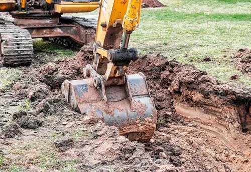 A heavy-duty excavator digging into the soil, showcasing Earthworks Hawkes Bay’s expertise in site preparation.
