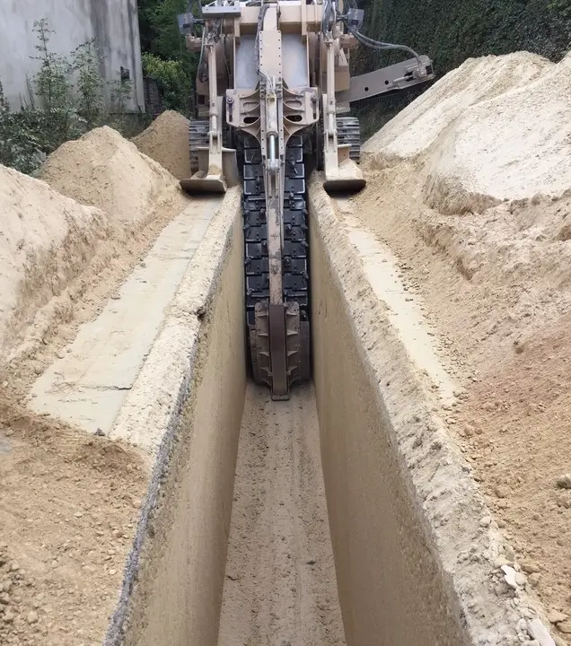 A heavy-duty trencher cutting through soil for pipeline installation, demonstrating Earthworks Hawkes Bay’s trenching efficiency.