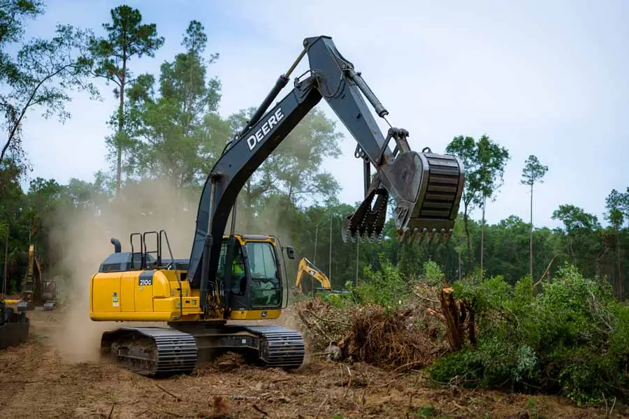 A powerful excavator removing trees and vegetation, a key step in Earthworks Hawkes Bay’s land clearing process.
