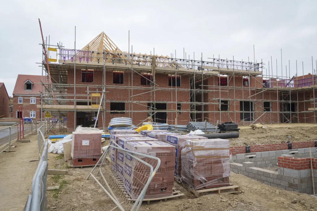 A residential building under construction with scaffolding, showing Earthworks Hawkes Bay’s role in site preparation for new developments.