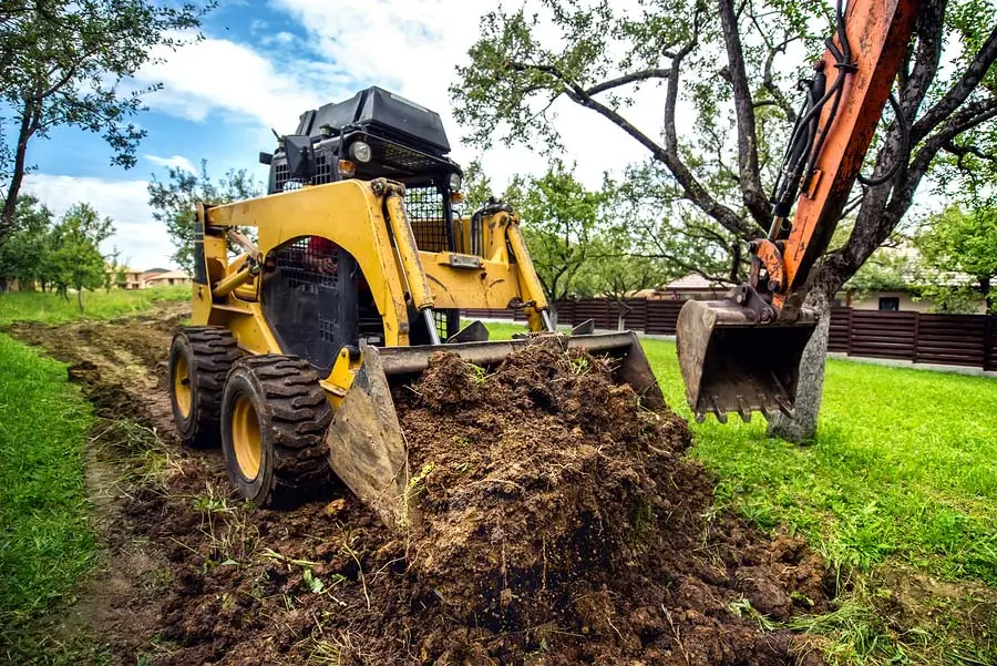 A skid steer loader lifting soil, part of Earthworks Hawkes Bay’s comprehensive land clearing solutions.