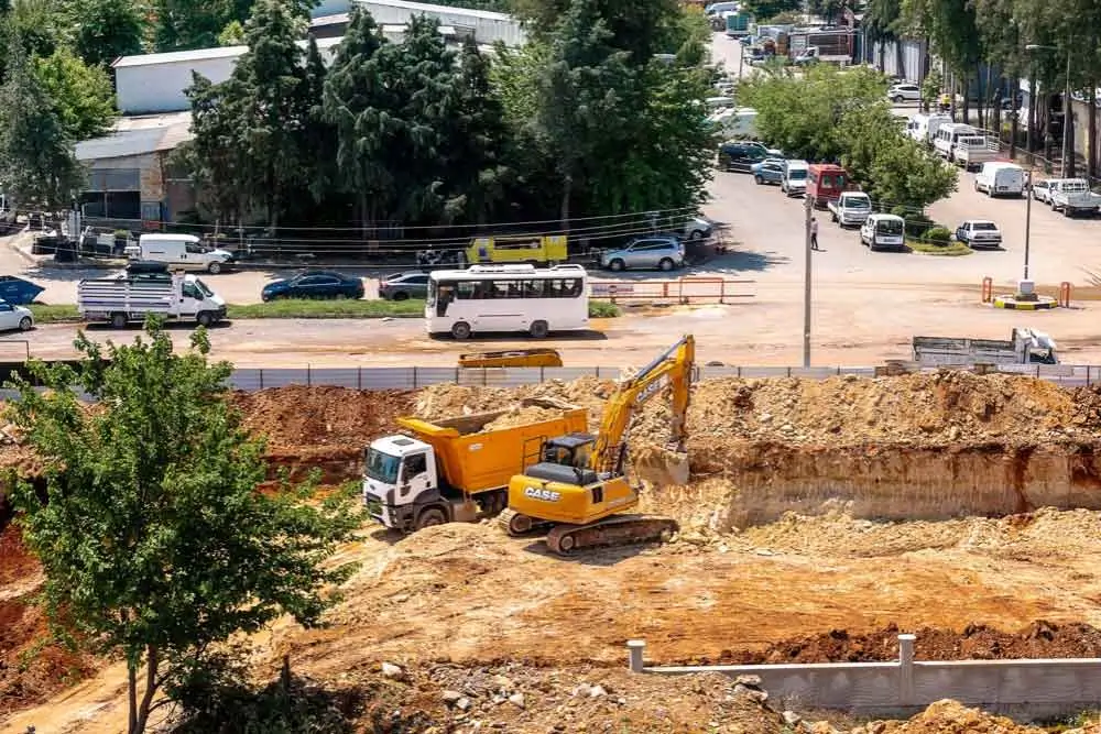 Excavators and dump trucks in action on a busy construction site, showcasing Earthworks Hawkes Bay's comprehensive site preparation services.
