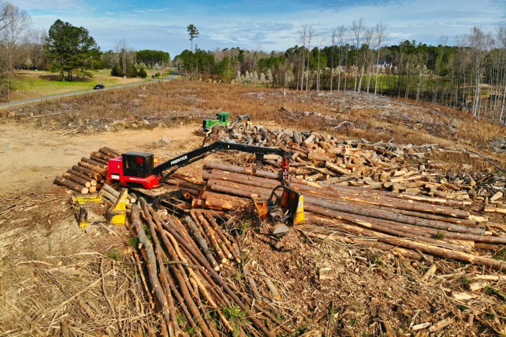 Heavy machinery clearing logs and debris as part of Earthworks Hawkes Bay's land clearing service.